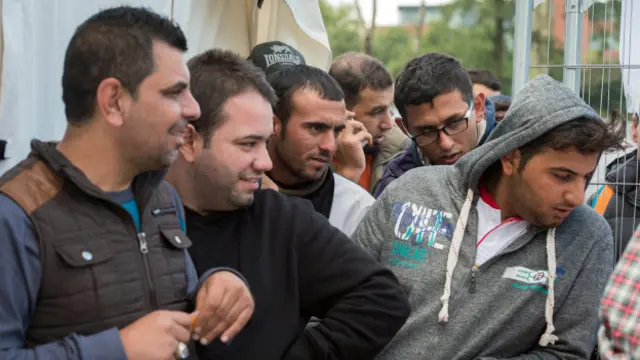 Refugiados em fila para receber roupas em Bruxelas (Foto: Stephanie Lecocq/EPA)