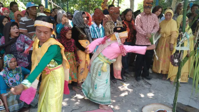 Seorang bayaha dan makatoko ka'ada menari mengelilingi pohon vunja dalam ritual Mora'akeke di Kabupaten Sigi, Sulawesi Tengah.