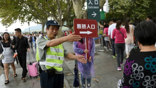 一名保安在西湖向游人指示路线