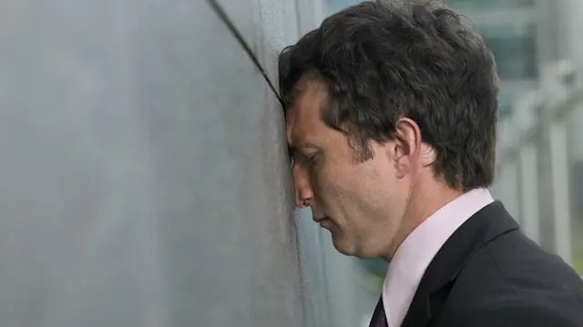 Мужчина лбом к стене