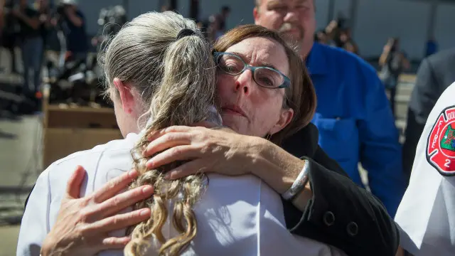 俄勒冈州州长凯特·布朗(右)与救护人员拥抱