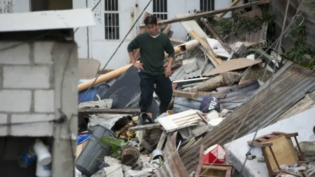 Un hombre se para en medio de los escombros