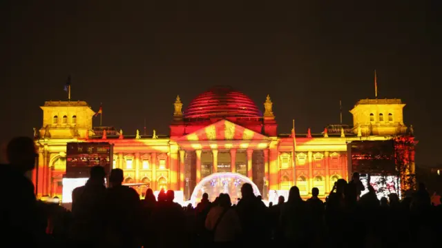 Reichstag terlihat bercahaya dengan permainan lampu pada perayaan peringatan 25 tahun penyatuan Jerman pada 3 Oktober 2015. 