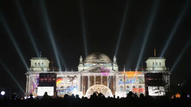 Reichstag terlihat bercahaya dengan warna-warna pada perayaan 25 tahun reunifikasi Jerman pada 3 Oktober 2015 di Berlin, Jerman. 