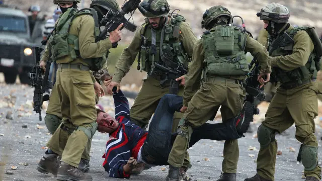 جنود إسرائيليون يعتقلون فلسطينيا خلال مواجهات في بيت ايل بضواحي الضفة الغربية.