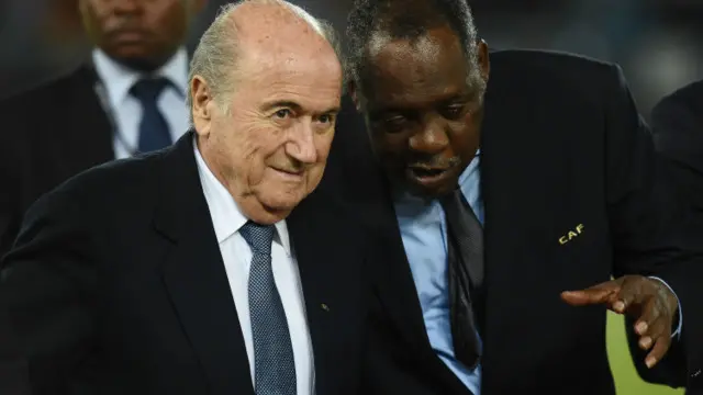 Issa Hayatou (kanan) yang mengepalai konfederasi sepak bola Afrika akan bertindak sebagai presiden FIFA selama Blatter diskors. 