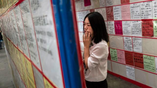 Jovem vê vagas de emprego em centro de Yiwu, na China (Foto: Kevin Frayer/Getty Images)