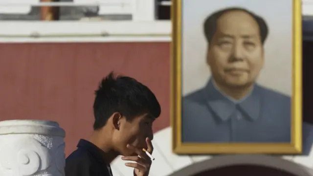 一名银川烟民在毛泽东肖像前吸烟