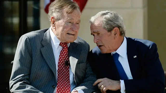 Cựu tổng thống George W. Bush (phải) nói chuyện với cha, Tổng thống George H.W. Bush, tại lễ khai trương Trung tâm Tổng thống George W. Bush năm 2013