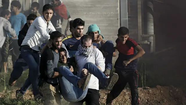 Palestinos cargan a un hombre herido durante los enfrentamientos.