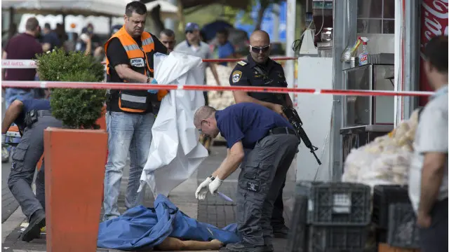 الشرطة الإسرائيلية تأخذ بصمات شاب فلسطيني قتل برصاصها، بعد أن طعن ، حسبما قيل، إسرائيليا بسكين قرب بوابة دمشق في القدس الشرقية.