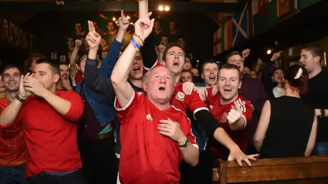 威尔士球迷在卡迪夫一家酒吧内庆祝球队晋身2016年欧洲杯