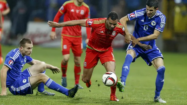 波黑球员（蓝）在比赛中夹击威尔士球员