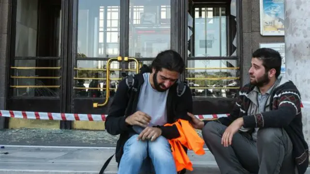 Estos dos sobrevivientes se sentaron en las escaleras de la estación de tren, donde se puede apreciar el impacto de las explosiones.