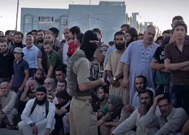 مردم برای تماشای اعدام جمع شده‌اند (برگرفته از یک ویدئوی دولت اسلامی، ۲۹ ژوئیه ۲۰۱۵)