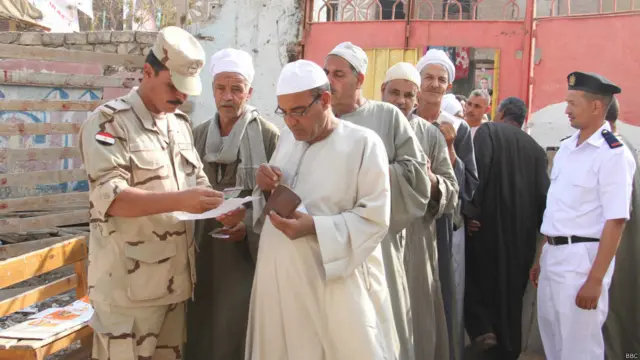 أحد أفراد الجيش يفحص هوية ناخب