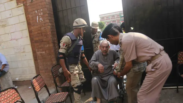 رجل مسن معاق يدخل لجنة الاقتراع للتصويت