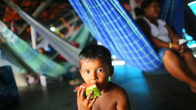 Un niño indígena comiéndose una manzana