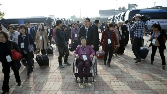 Ailə üzvlərinin müşayiəti ilə görüşə gələn Cənubi Korealıların qrupu sərhədi keçərək Şimali Koreyaya daxil olur.