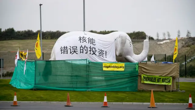在欣克利角核电站附近，反核人士打出中英双语标语，表达对核电的不同看法。