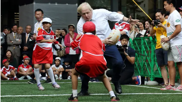 伦敦市长鲍里斯·约翰逊出访日本,于小学生玩榄球
