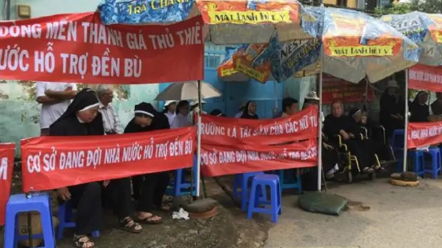 Các nữ tu Dòng Mến Thánh Giá Thủ Thiêm căng băng rôn và cầu nguyện