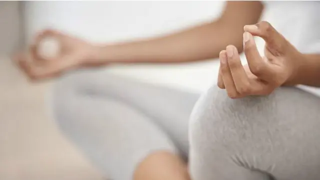 Una persona con las piernas cruzadas en el piso