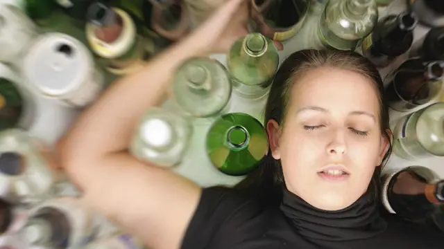 Девушка на полу среди бутылок