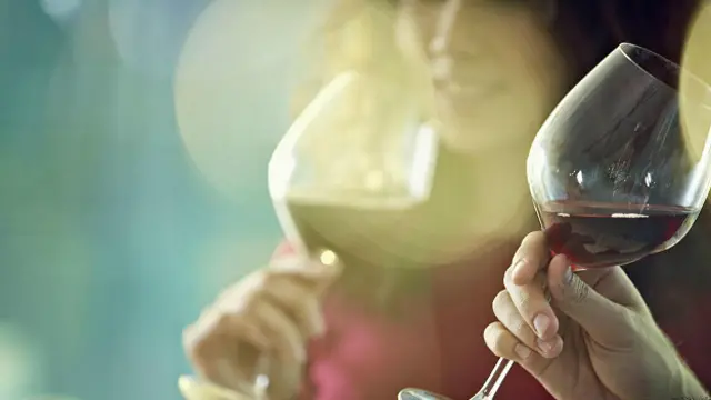 Улыбающаяся девушка с бокалом вина