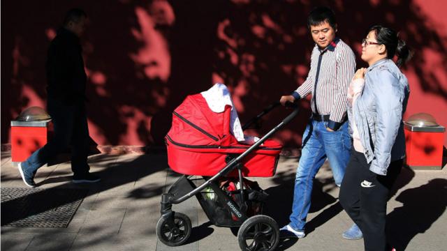 一对父母在北京推着婴儿车