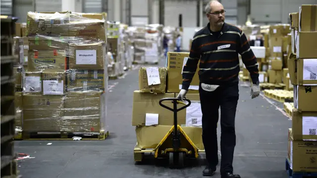 Sukarelawan mengorganisir donasi pakaian di pusat penampungan sumbangan di hall pameran Messe di Hamburg, Jerman.