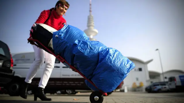 Sukarelawan mengangkut sumbangan pakaian ke dalam hall pameran Messe, Hamburg, Jerman, yang menjadi tempat penampungan dan pengaturan donasi buat migran.