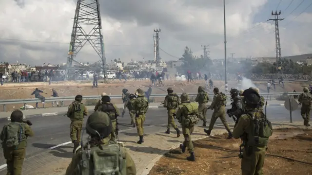 Tentara Israel melempar granat ke arah warga Palestina di Tepi Barat, di lokasi dugaan serangan terhadap tentara Israel oleh seorang perempuan Palestina pada November 2015.