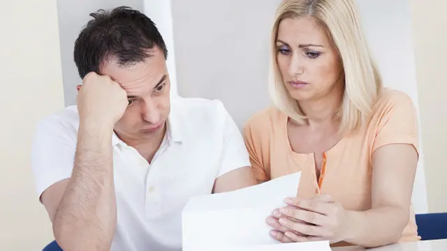 Муж и жена рассматривают огромный счет