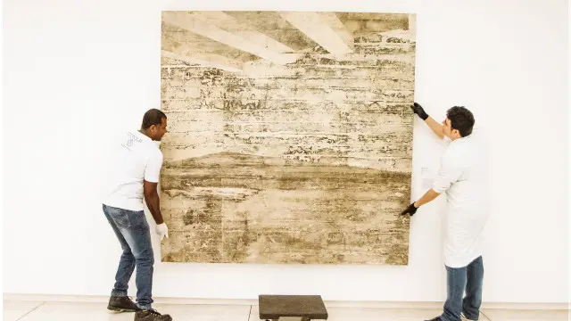 A obra “Galeria”, de 2002, de Daniel Senise, é levada por técnicos do museu Oscar Niemeyer durante desmontagem da exposição. Obras ficarão em acervo técnico à espera de decisão judicial.