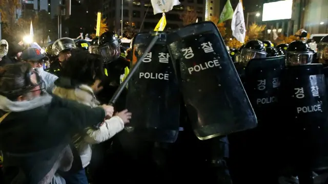 Polisi berusaha menghalau massa yang berusaha menembus barikade dengan menggunakan gas air mata dan meriam air.