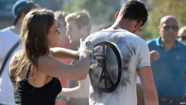 Biểu tượng hòa bình với hình Tháp Eiffel đang được vẽ lên áo phông trước khi diễn ra buổi lễ tưởng niệm ở Melbourne, Australia.