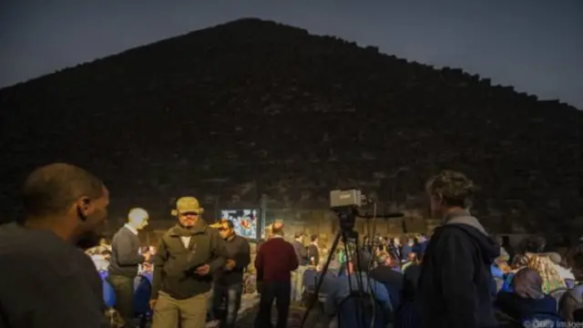 باحثون يقفون بجوار الهرم الأكبر بالجيزة خلال التجربة الخاصة بالتصوير الحراري بالأشعة تحت الحمراء للأهرامات من أجل التعرف على ملامح البصمة الحرارية للجدران.