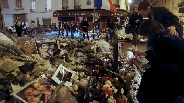 فرنسيون يضعون الشموع أمام مقهى لو كارليون، الذي تعرض للهجوم يوم الجمعة الماضي.