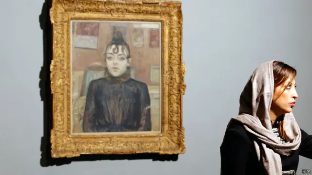 فتاة إيرانية تقف الى جانب لوحة للفنان الفرنسي تولوز لوتريك في المعرض