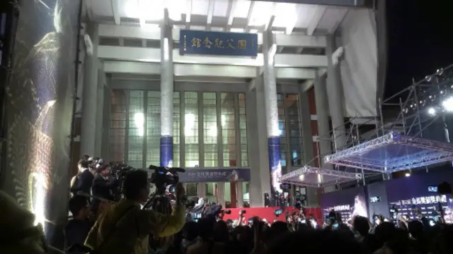 尽管傍晚下着细雨,场外观众热情不减。