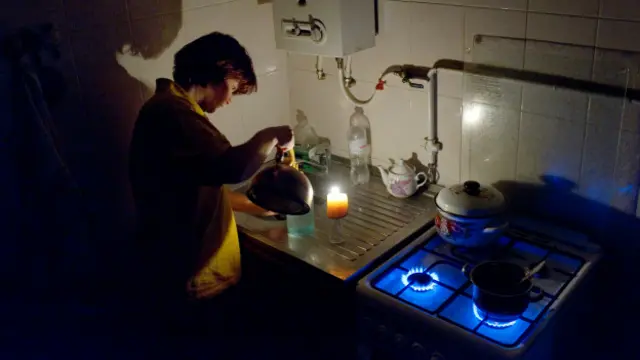 Жунщина на кухне со свечкой