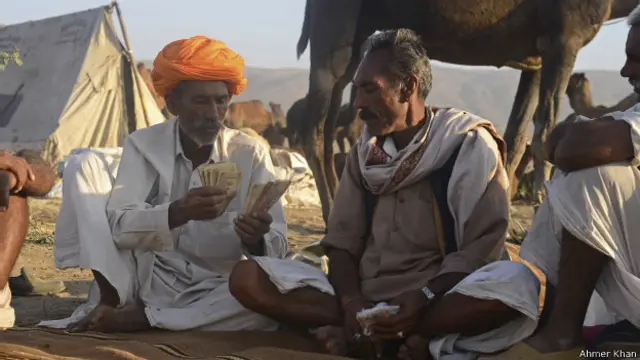 मेले में ऊंट बेचने के बाद पैसा गिनते ऊंट पालन वाले.