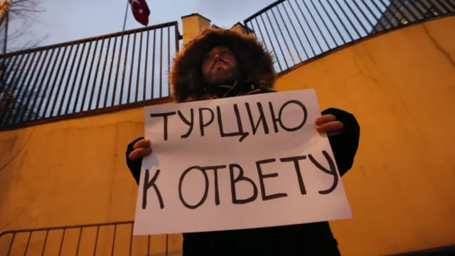 Человек с плакатом "Турцию к ответу" у турецкого посольства в Москве