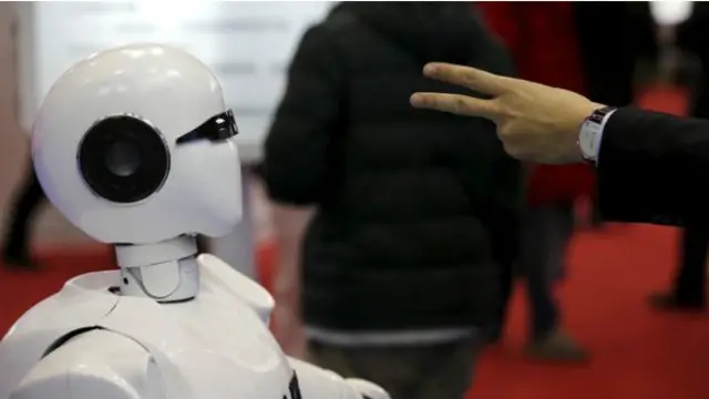 ایک شخص ہاتھ سے قینچی بنا کر روبوٹ کو دھوکا دینے کی کوشش کر رہا ہے