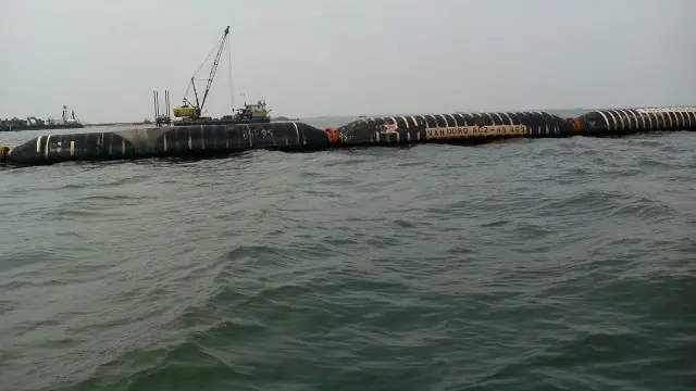 Pipa yang menyedot dan membuang lumpur di kawasan reklamasi.