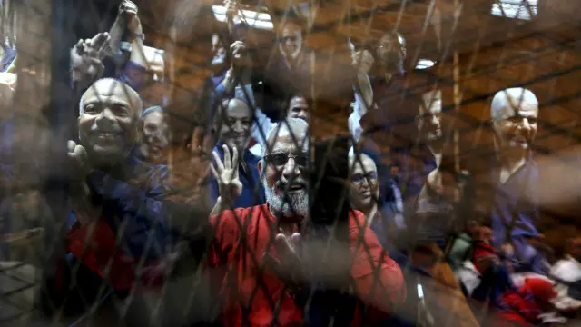 الزامات کا دفاع کرنے والے اخوان المسلمون کے حامی چار انگلیوں سے اپنا مخصوص سلام کرتے ہوئے