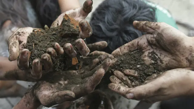 在菲律宾的行动者用泥土而碎砖块比喻气候变化造成的冲击。