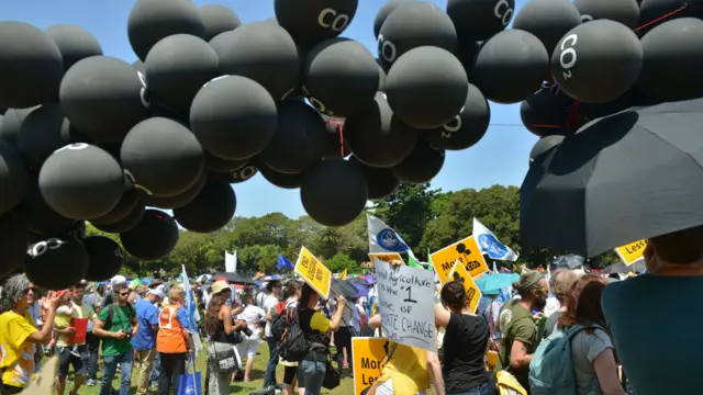 在悉尼的游行者用黑色气球代表二氧化碳,呼吁政府采取行动。