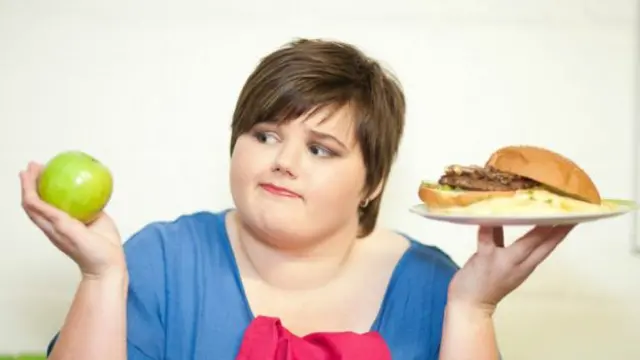 Женщина с бургером и яблоком